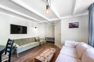 a living room with a couch and a table at Kongshamn Gjestgiveri in Kirkehamn