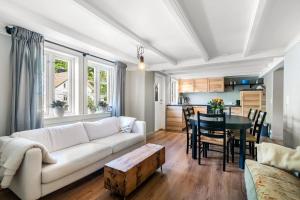 a living room with a white couch and a table at Kongshamn Gjestgiveri in Kirkehamn