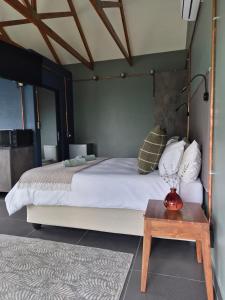 a bedroom with a large bed and a table at Febe-Mari Guesthouse in Zeerust