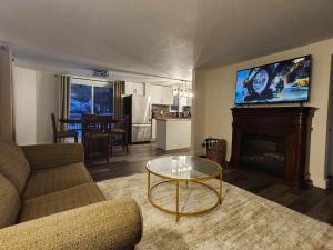 a living room with a couch and a table and a tv at Getaway by the bay in Owen Sound