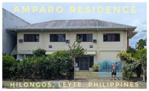 a boy standing in front of a house at Amparo Residence, Arayat Room in Hilongos