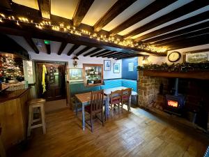 a dining room with a table and a fireplace at The Pear Tree in Hook Norton