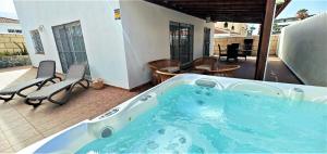 a jacuzzi tub on the patio of a house at Villa Iris in Callao Salvaje