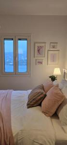 a bedroom with a bed with two windows at Thalassa in Perdika