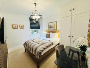 a bedroom with a bed and a chandelier at Luxury 2 Bed Designer Apartment & Garden in Bexleyheath
