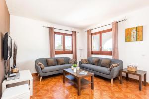 a living room with two couches and a tv at Villa Dulcesol by Villa Select in Alaior