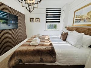 a bedroom with a large bed with towels on it at Luxury 2 Bed Designer Apartment & Garden in Bexleyheath