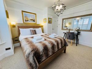 a bedroom with a large bed with two towels on it at Luxury 2 Bed Designer Apartment & Garden in Bexleyheath