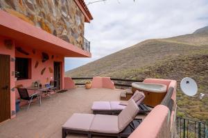 a balcony of a house with pink furniture and a mountain at Apartamento Vulcano in Adeje