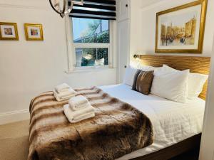 a bedroom with a bed with towels on it at Luxury 2 Bed Designer Apartment & Garden in Bexleyheath