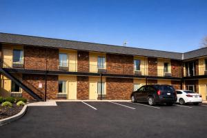 a building with a car parked in a parking lot at The Queen B Motel, Detroit-Warren in Warren
