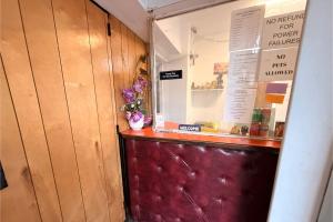 a shop with a counter with a vase of flowers at The Queen B Motel, Detroit-Warren in Warren