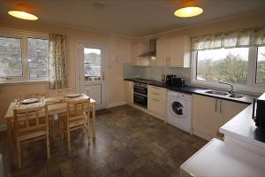 a kitchen with a table and chairs and a kitchen with a sink at Correay Cottage in Salen