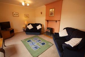 a living room with a couch and a chair at Correay Cottage in Salen