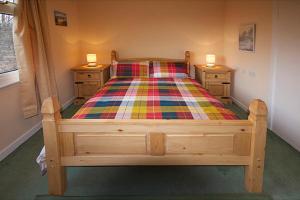 a bedroom with a wooden bed with two night stands at Correay Cottage in Salen