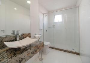 a bathroom with a shower and a sink and a toilet at Hotel Açores Premium- 5 minutos do Moinhos de Vento in Porto Alegre