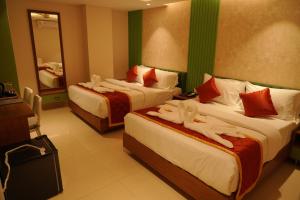 a hotel room with two beds with people on them at Majesty inn in Bangalore