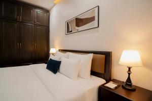 a bedroom with a bed with a nightstand and a lamp at Hai An Hotel Suites Ha Noi in Hanoi +94 photos