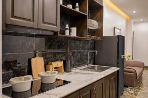 a kitchen with a black refrigerator and a counter at Hai An Hotel Suites Ha Noi in Hanoi