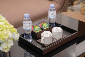 a tray with two bottles of water and two cups at Hai An Hotel Suites Ha Noi in Hanoi