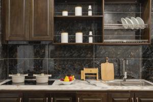 a kitchen with a sink and a counter with a bowl of fruit at Hai An Hotel Suites Ha Noi in Hanoi