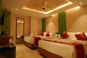 a bedroom with two beds with green and white at Majesty inn in Bangalore
