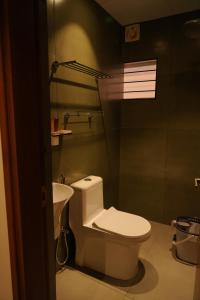 a bathroom with a toilet and a sink at Majesty inn in Bangalore
