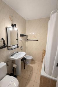 a bathroom with a sink and a toilet and a mirror at Hostal Prada in Madrid