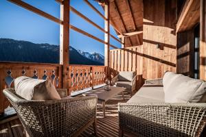 a room with chairs and tables on a balcony with mountains at Apartment Danton, Châtel - by EMERALD STAY in Châtel