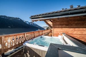 a hot tub on the balcony of a house at Apartment Danton, Châtel - by EMERALD STAY in Châtel