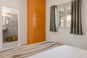 a bedroom with a bed with a mirror and a window at Lourdas Sunshine in Lourdata +17 photos