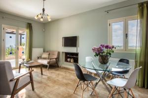 a living room with a glass table and chairs at Athina Rose in Trapezaki