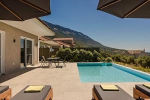 a patio with a swimming pool and a table and chairs at Lourdas Sunshine in Lourdata