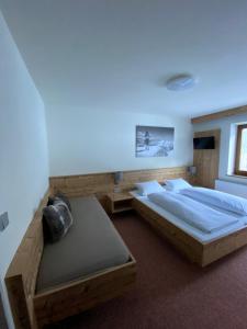 a bedroom with two beds and a blue light at Strubwirt in Waidring