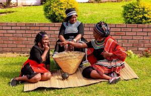 a group of three women sitting on the grass at Amazing Grace Inn BnB in East London +9 photos