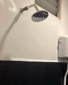 a shower head on a wall in a bathroom at Temin Roomstay in Pulau Langkawi +1 photo