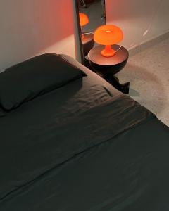 a bed with an orange lamp next to a table at Temin Roomstay in Pulau Langkawi