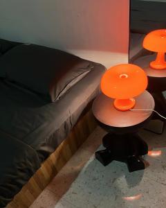 two tables with orange plates on them next to a bed at Temin Roomstay in Pulau Langkawi