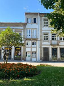 a large white building with a tree in front of it at Arcanjo Hostel 2 in Braga