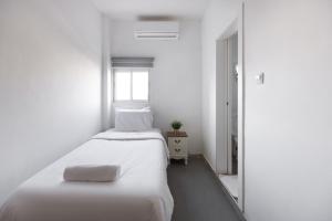 a white bedroom with a bed and a window at Bella Vista House - בלה ויסטה האוס in Eilat