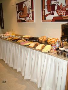 a buffet line with many different types of sandwiches and bread at Hotel Recanto do Imperador in Rio Pardo