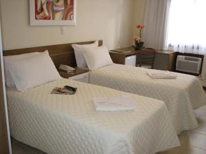 a hotel room with two beds with towels on them at Hotel Recanto do Imperador in Rio Pardo +23 photos