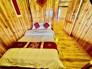 a bedroom with a bed in a wooden cabin at H'mong Village Homestay in Sapa