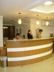 a group of people sitting at the counter of a salon at Hotel Recanto do Imperador in Rio Pardo