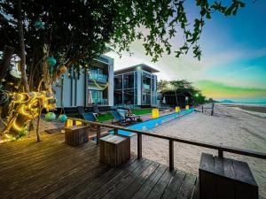 a house on the beach with a deck and a building at Leamsai Beach Resort in Suratthani
