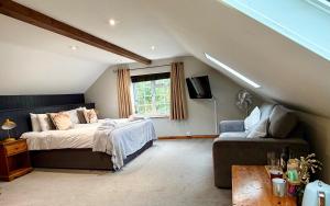 a bedroom with a bed and a couch at The Pear Tree in Hook Norton