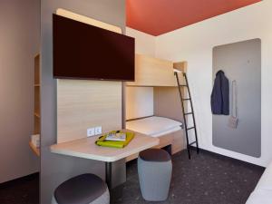 a small room with a desk and a bunk bed at B&B HOTEL Kassel-Wilhelmshöhe in Kassel