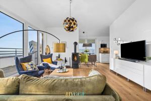 a living room with a couch and a tv at Penthouse Hygge Meerblick - Olpenitz in Olpenitzdorf