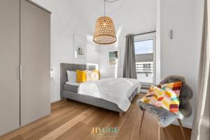 a bedroom with a bed and a chair and a window at Penthouse Hygge Meerblick - Olpenitz in Olpenitzdorf