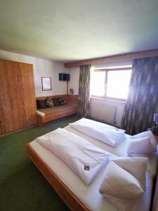 a bedroom with two beds and a window at Strubwirt in Waidring